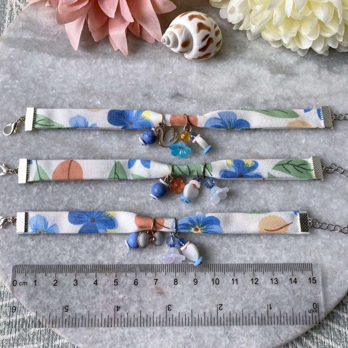 Bracelet tissu fleuri blanc et bleu à breloques