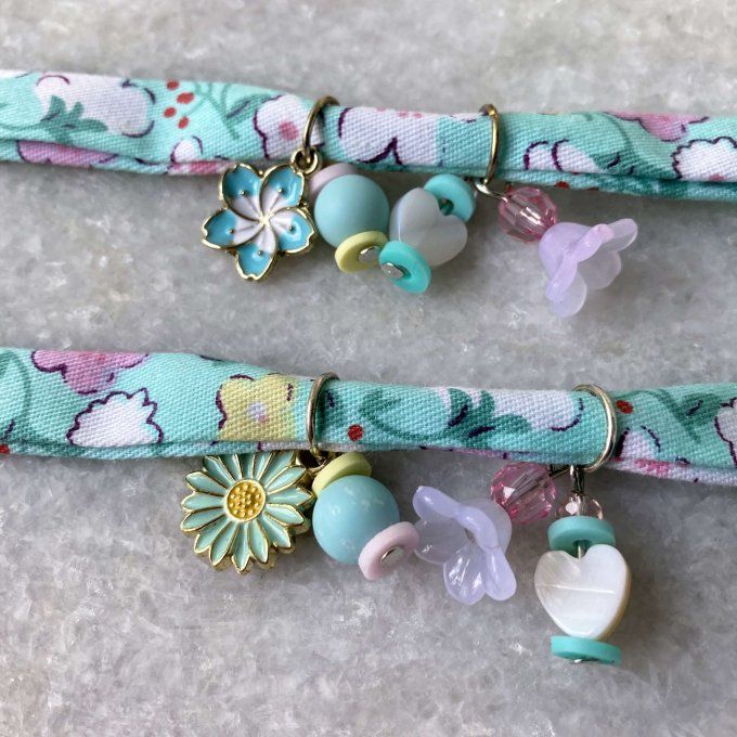 Bracelet en tissu fleuri vert turquoise, blanc, rose et jaune à breloques