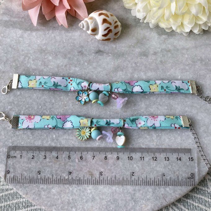 Bracelet en tissu fleuri vert turquoise, blanc, rose et jaune à breloques